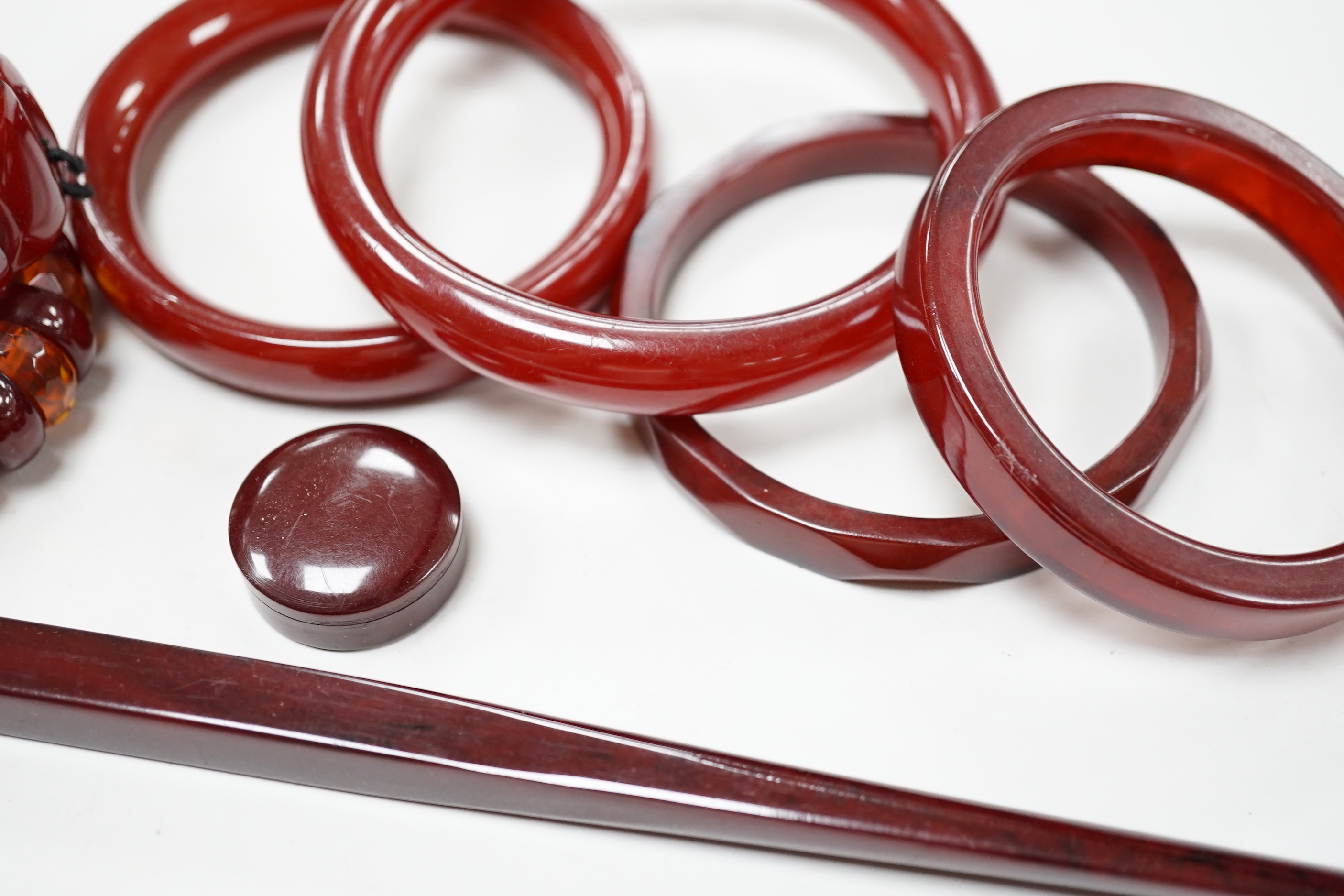 Eight simulated cherry amber items including four bangles and two bracelets.